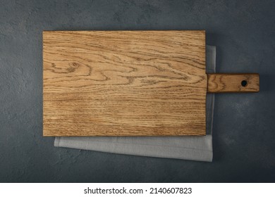 An old cutting board over a towel on a stone kitchen table. Flat lay top view with copy space