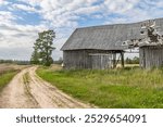 Old, damaged asbestos slate roof with a roof window for an abandoned farm. Asbestos-containing products have been banned in the European Union since 2005 because they are harmful to health.