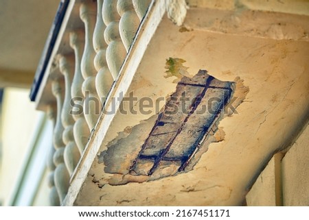 Old damaged balcony. Emergency balcony, with cracked concrete. Balcony repair, cracks in reinforced concrete structure. Risk of falling plaster or concrete on pedestrians
