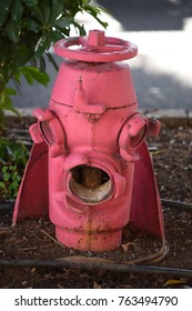 Old and damaged hydrant in pink