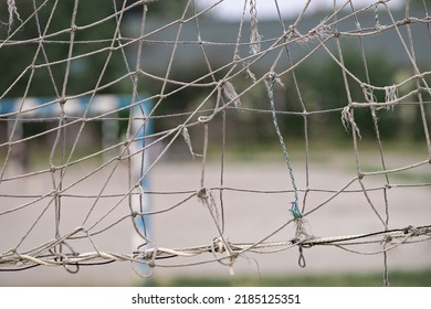 Old damaged volleyball net, close-up. Sports equipment. Old beach volleyball net, selective focus.
