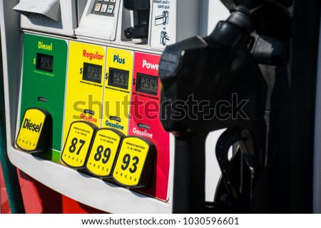 Old dangerous combustible petrol chemical gas. At the Gas station. Filling up gasoline at the gas pump. 87 octane , 89 octane , or 93 octane. With gas pump handle ready to fill up the tank