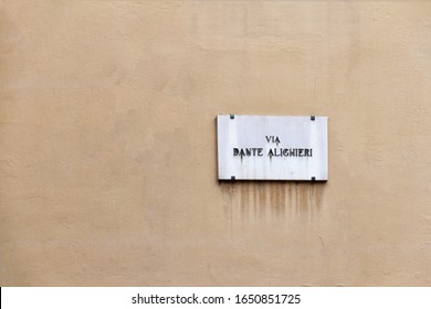 Old Dante Alighieri Street Nameplate On Ancient Yellow Wall In Florence In Italy