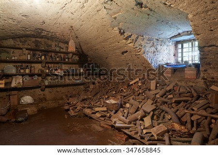 Old, dark basement with wood pile in ancient house