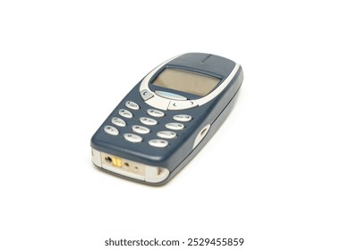 Old dark push-button mobile phone isolated on white background. Mobile phone with buttons.