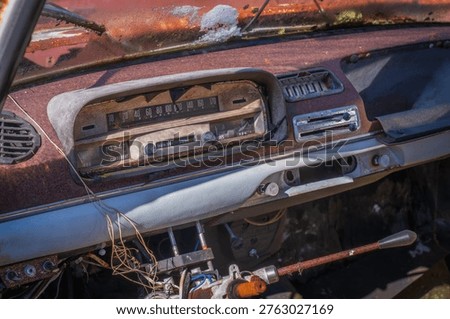 Old dashboard with speedometer and controls showing wear, corrosion and classic automotive design.