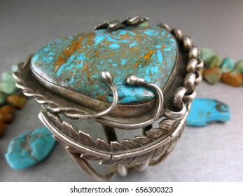 Old Dead Pawn Jewelry Display Of A Native American Cuff Bracelet With A Huge Turquoise Surrounded By Snakes And Prayer Feathers