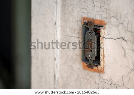 Old decapitated wall with a weathered light switch set in the off position