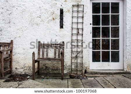 Old decayed chair and vine rack in backyard