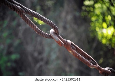 Old, decayed wire, rusted steel sling Rusted wire rope hanging from a bridge But still strong and usable
