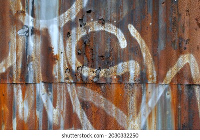 Old Defaced Rusty Corrugated Iron Wall in Close Up