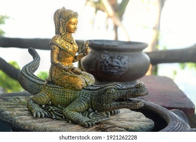 old deity sculpture in garden Buddhist temple. national art concept. Buddhism culture symbol. relax spiritual travel. stone figure of women Asian deity and crocodile. religious, spiritual symbol