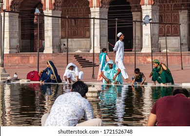 Old Delhi, Delhi, India - 05/04/2019: A Group Of Women Washing Hands And Feet At A Common Water Pond Before Prayer At Jama Masjid. People Cleaning With Same Water Together At An Islamic Mosque.