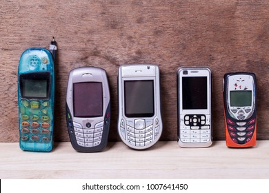 Old Design Collection Of Cell Phones Isolated On Wood Background