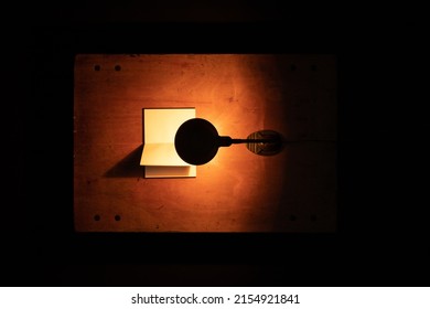 An Old Desk Lamp Shines On An Open Blank Notebook. Conceptual Photography.