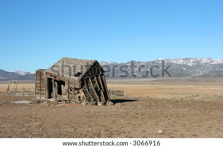 An old dilapidated shack sits in an empty field