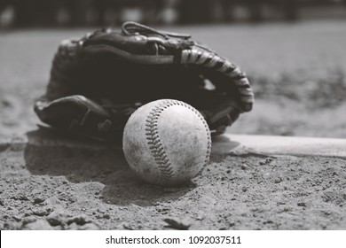 Old Dirty Baseball With Glove On Dirt Field Brings Back Nostalgia Of Sports Memories For Ball Player In Black And White.