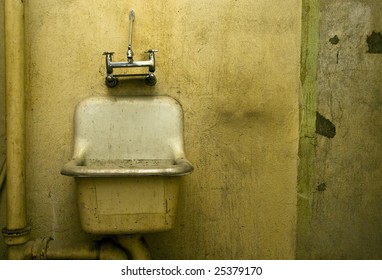 An Old Dirty Bathroom Sink In A Decrepit Building.