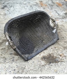 Old And Dirty Black Plastic Clam Shell Shaped Basket On Concrete Ground