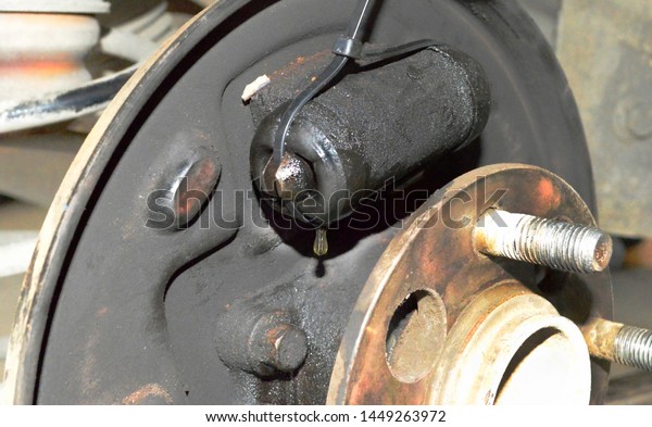 Old dirty brake cylinder with leakage of brake fluid.\
Rusty wheel hub 