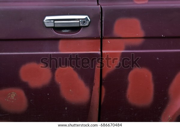 The old\
dirty car doors are covered with paint\
spots