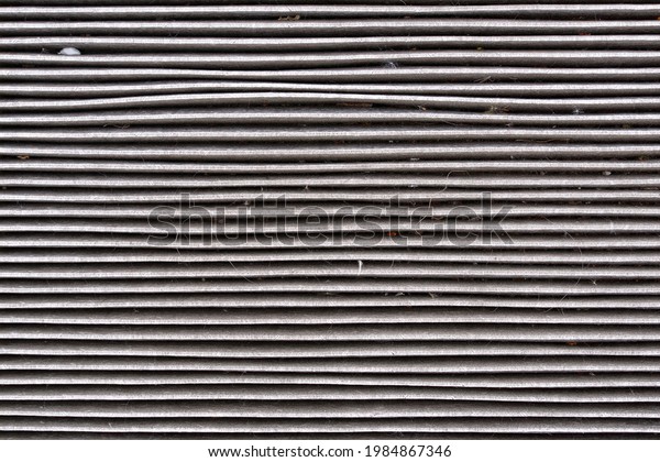 Old and dirty carbon air filter\
for car ventilation system, macro shot. Activated carbon absorbent\
fibers arranged In horizontal lines. Purifying air\
element.