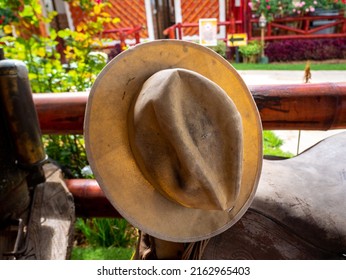 Old And Dirty Hat In The Field Leaning Against A Fence