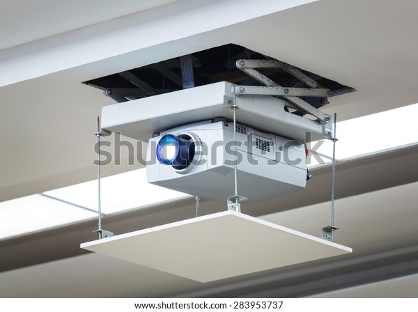 Old and dirty projector hang on ceiling in\
meeting room, education\
concept