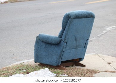 Old Dirty Recliner Chair On Sidewalk In Impoverished Neighborhood 