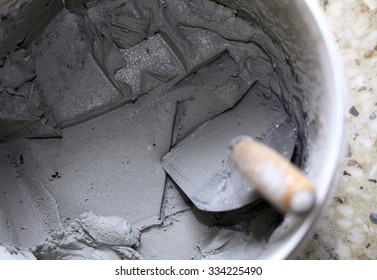 Old Dirty Trowel And Bucket With Mortar On Construction Building Site