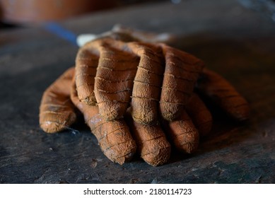 Old Dirty Work Gloves On A Wooden Background.