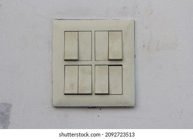 Old dirty yellowed light switches on the wall.