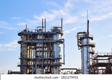 Old Distillation Column Towers With Blue Sky With Clouds Background At Chemical Plant. Exterior Of Silver Metal Rusty Methanol Distillation Enterprise With Copyspace .