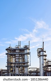 Old Distillation Column Towers With Blue Sky With Clouds Background At Chemical Plant. Exterior Of Silver Metal Rusty Methanol Distillation Enterprise Vertical With Copyspace.