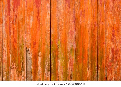 Old distressed orange wooden planks wall with peeling paint and damo, rustic grunge background or texture 