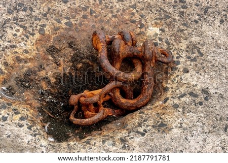 Old disused rusting steel shackles at a coastal harbour location
