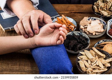The old doctor of traditional Chinese medicine to the patient's pulse - Shutterstock ID 2159935859