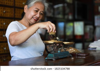 The Old Doctor Of Traditional Medicine Weight Scales Dry Lotus Pollen China Herbs In Chinese Medicine Shop.