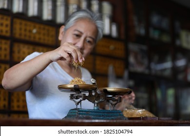 The Old Doctor Of Traditional Medicine Weight Scales Dry Lotus Pollen China Herbs In Chinese Medicine Shop.