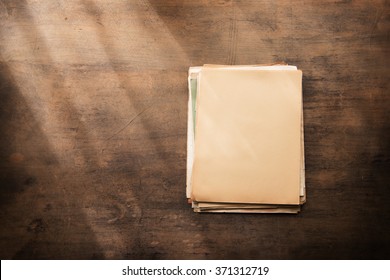 Old documents in blank on a old wooden desk, with by the window type light coming in. Ready for inserting your message or text. 