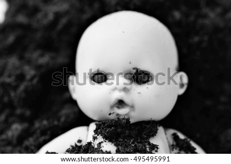 Old doll lost in the mud
