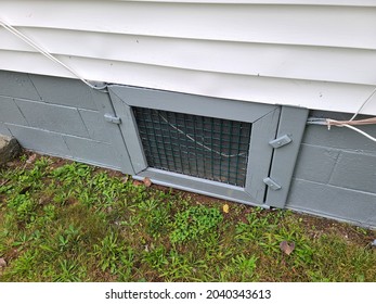 An Old Door At The Bottom Frame Of A House. The Small, Hidden Door Leads To The Cellar And Crawl Space Below The House.