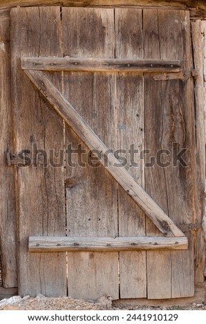 old door made of wooden planks, with iron hinges and locks, beautiful wood textures