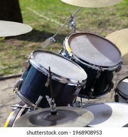 Old Drum Kit On Green Grass And Stone Pavement Background, Outdoor Street Music Entertainment