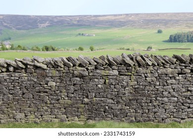 Old dry stone wall, with green countryside and moorland beyond - Powered by Shutterstock