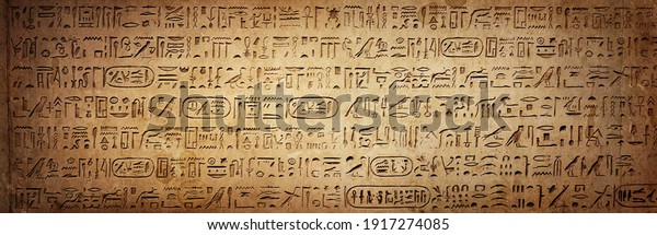 Old Egyptian hieroglyphs on an ancient\
background. Wide historical background. Ancient Egyptian\
hieroglyphs as a symbol of the history of the Earth.\
