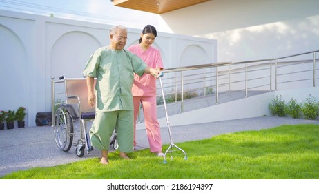 Old Elderly Asian Patient Or Pensioner People Walking By Walker With A Nurse, Relaxing, In Nursing Home In Garden Park. Senior Lifestyle Activity Recreation. Retirement. Health Care Physical Therapy.