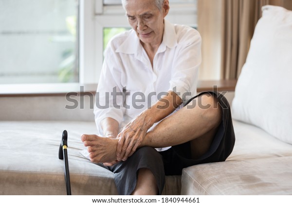 Old elderly with foot injuries,ankle bone\
diseases,heel pain or soles,asian senior woman suffering from\
peripheral neuropathy,beriberi,nerve inflammation of the foot,\
numbness of the feet and\
toe