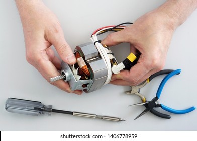 Old Elderly Home Craftsman Repairs The Electric Motor From  Mincer. Home Closeup  Shot