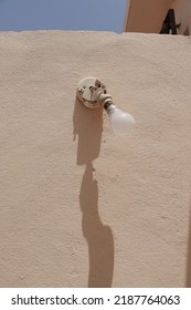 Old Electric Lamp On The Yellow Wall. Ancient And Rusty Electric Articles
